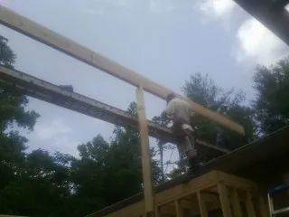 Carpenter setting a ridge beam over a new addition frame — Ice Dam Removal by Roofing Brothers in Veyo