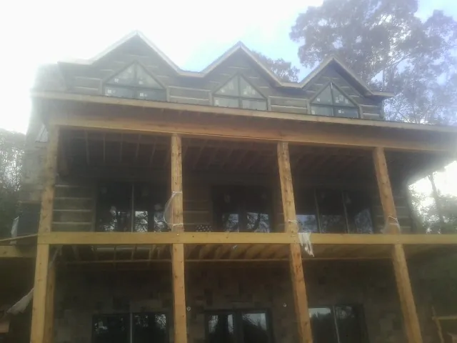 Dormers and porch framing on a large log home under construction — Roof Coating work by our crew in Veyo