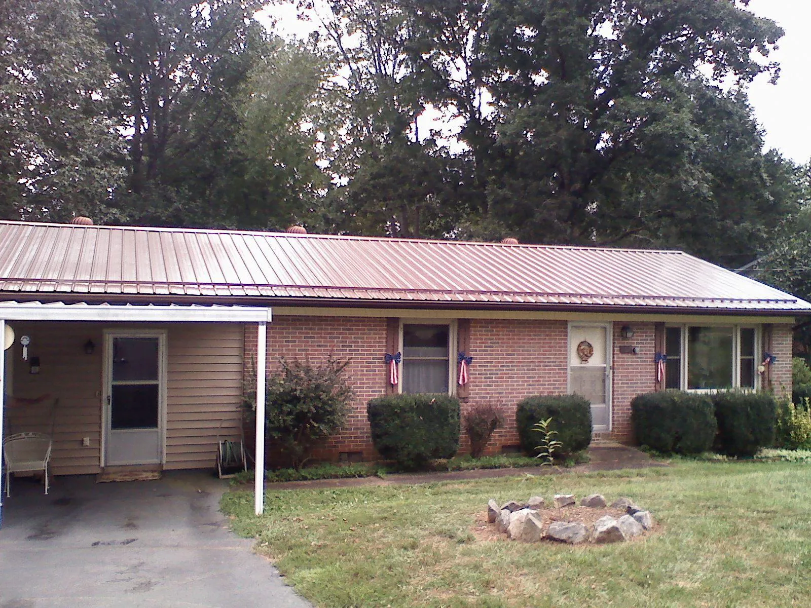 Bronze metal roof and carport on a brick ranch home — Roof Repair work by our crew in Veyo